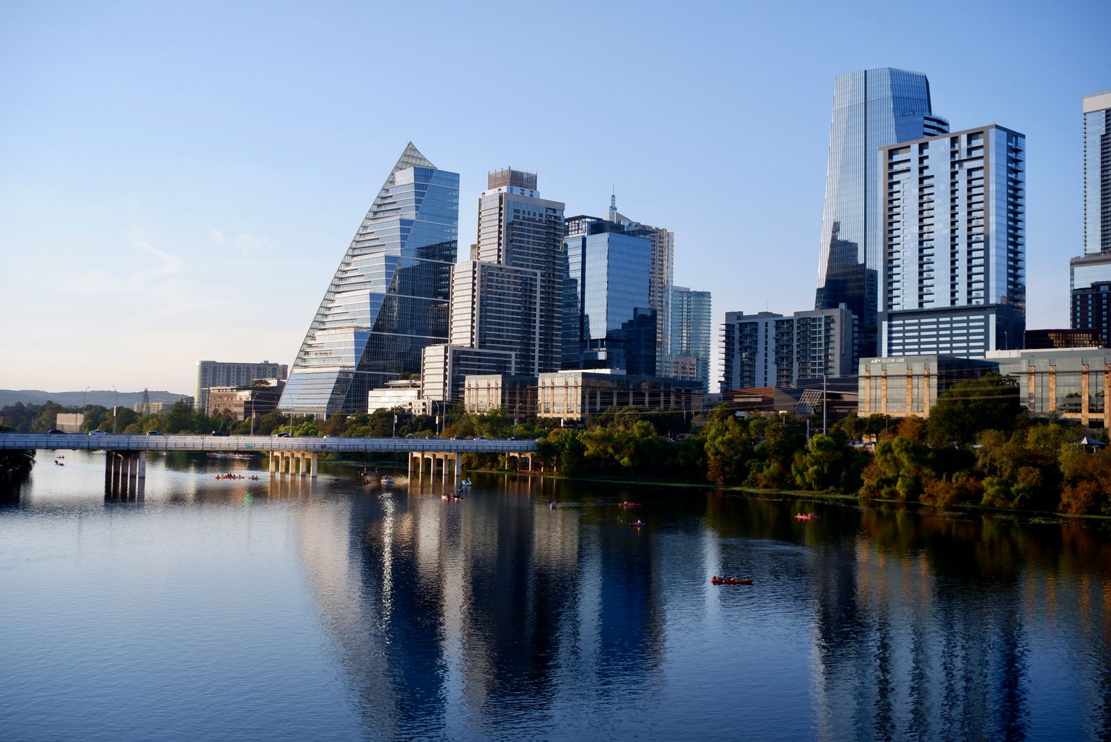 Calm water reflecting a city skyline in soft morning light